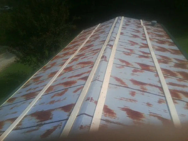 Rusted metal roof panels with new wood purlins before replacement — Storm Damage Roof Repair in Bomont by Roofing Brothers