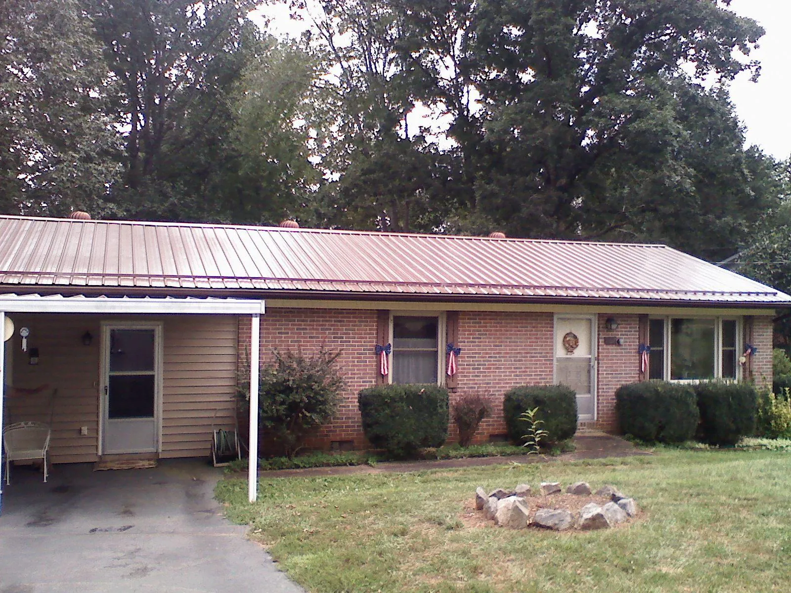Bronze metal roof and carport on a brick ranch home — Roof Repair work by our crew in Bomont